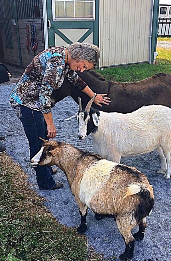 Joyce Renner on farm with goats and other animals.